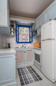 a kitchen with a white refrigerator and a window at Absolute Perdika Aegina in Perdika