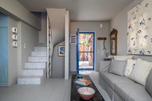 a living room with a couch and a staircase at Absolute Perdika Aegina in Perdika