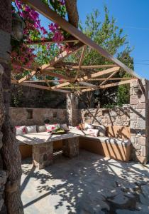 a patio with a bench under a wooden pergola at Absolute Perdika Aegina in Perdika