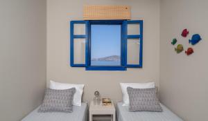 a room with two beds and a window at Absolute Perdika Aegina in Perdika
