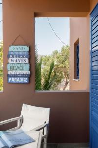 a room with a window and two chairs and a sign at Absolute Perdika Aegina in Perdika