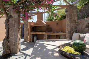an outdoor kitchen with a bowl of fruit on a patio at Absolute Perdika Aegina in Perdika