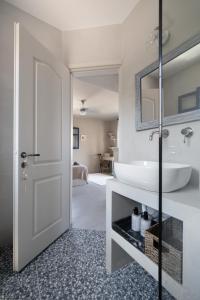 uma casa de banho com um lavatório branco e um espelho. em Absolute Perdika Aegina em Perdika
