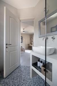 a bathroom with a white sink and a mirror at Absolute Perdika Aegina in Perdika