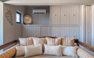 a couch with four pillows in a room at Absolute Perdika Aegina in Perdika