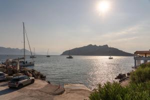 a car parked next to a body of water with boats at Absolute Perdika Aegina in Perdika