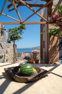a watermelon is sitting on a plate on a patio at Absolute Perdika Aegina in Perdika