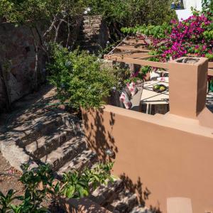 a row of tables and flowers on a wall at Absolute Perdika Aegina in Perdika