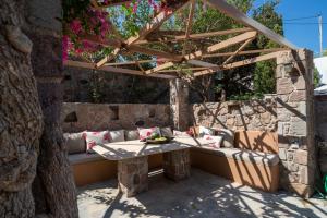 a patio with a table and a wooden pergola at Absolute Perdika Aegina in Perdika