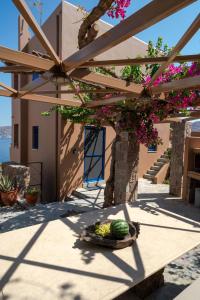 a basket of watermelons on a table under a pergola at Absolute Perdika Aegina in Perdika