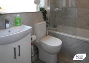 a bathroom with a white toilet and a sink at Luke Stays - Brinkburn Avenue in Gateshead