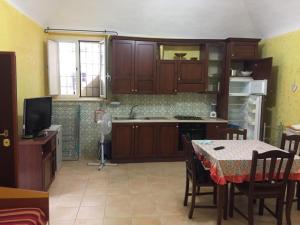 una cocina con armarios de madera y una mesa con mantel. en Marcella Holiday House, en Vietri