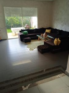 a living room with a couch and a table at Sidi Rahal Villa avec piscine à 5min de la plage in Dar Hamida