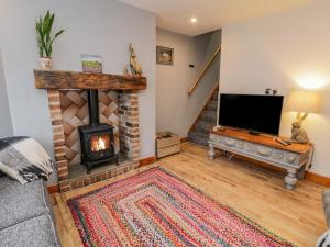 a living room with a fireplace and a tv at Henrietta's Cottage in Guisborough
