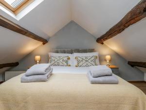 a bedroom with a large bed with two pillows on it at Henrietta's Cottage in Guisborough
