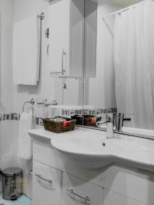 a white bathroom with a sink and a mirror at Afra Oghuz Mountain Resort Hotel in Oğuz