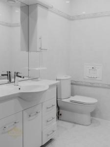 a white bathroom with a toilet and a sink at Afra Oghuz Mountain Resort Hotel in Oğuz