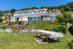 Una mesa y sillas frente a una casa en Finest Retreats - Avalon Sea Views, en Downderry