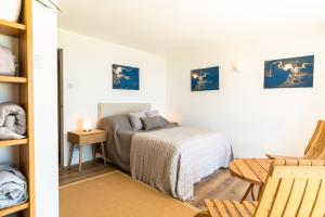 Un pequeño dormitorio con una cama y una silla. en Finest Retreats - Avalon Sea Views, en Downderry