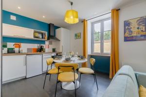 cocina y sala de estar con mesa y sillas en Mon Petit Sejour Lucon, en Luçon