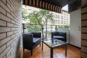 a balcony with two chairs and a glass table at Apartamento al lado de la Romareda in Zaragoza