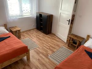 Zimmer mit 2 Betten, einer Kommode und einer Tür in der Unterkunft ZBYTINY in Zbytiny