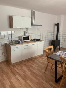 a kitchen with white cabinets and a table and a microwave at ZBYTINY in Zbytiny