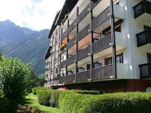 een gebouw met balkons en struiken naast een berg bij Appartement Chamonix-Mont-Blanc, 3 pièces, 6 personnes - FR-1-517-15 in Chamonix-Mont-Blanc