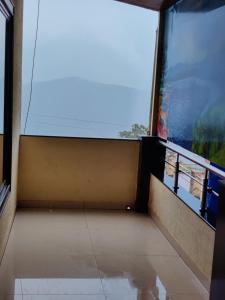 a room with a view of the ocean from a window at Hotel Adinath in Mahabaleshwar