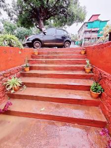 a car parked next to a set of stairs with potted plants at Hotel Adinath in Mahabaleshwar