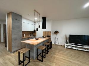 a kitchen with a table and some chairs and a tv at Apartament Szczytno - Centrum in Szczytno