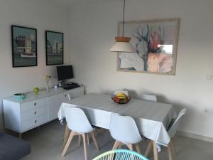 a dining room table with white chairs and a desk at Apartman ENA in Ivan Dolac
