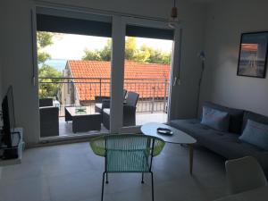 a living room with a couch and a table and a balcony at Apartman ENA in Ivan Dolac