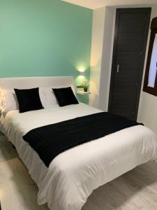 ein Schlafzimmer mit einem großen weißen Bett mit einer schwarzen Decke in der Unterkunft APARTAMENTO LAS NIÑAS in Ronda