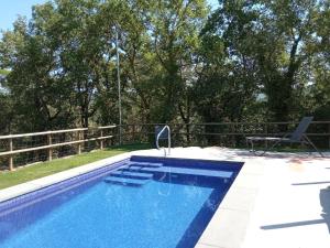 a swimming pool in a yard with a fence at Entre Roures in Moià