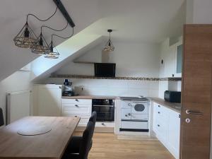 a kitchen with a wooden table and a dining room at Ferienwohnung Anika in Kleinlobming