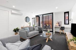 - un salon avec un canapé et une table dans l'établissement Pier Point 404- Luxe on Geelong Waterfront, 2 BDRM, à Geelong