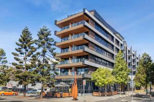 a tall apartment building with trees in front of it at Pier Point 404- Luxe on Geelong Waterfront, 2 BDRM in Geelong