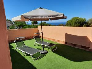 dos sillas y una sombrilla en el césped en Vivienda adosada con entrada independiente, en Marbella