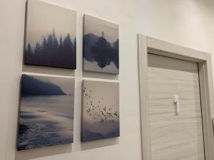 four pictures hanging on a wall next to a door at Sweet life La spezia Liguria in La Spezia