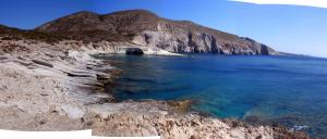 a large body of water next to a mountain at KAMEO, Antiparos in Antiparos