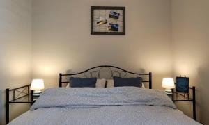 sypialnia z łóżkiem z niebieską pościelą i 2 lampami w obiekcie Apartament Dobre Miejsce w Olsztynie