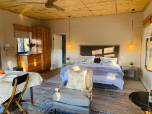 1 dormitorio con 1 cama, mesa y sillas en Namakwa Country Cottage, en Calvinia