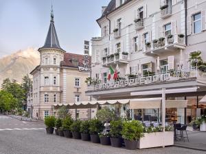 Un bâtiment avec une bande de plantes devant lui dans l'établissement Hotel Europa Splendid, à Merano