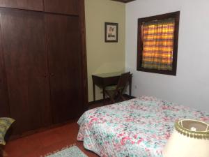 a bedroom with a bed and a table and a window at Casa Valverde in Cartaxo +15 photos