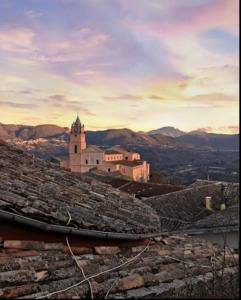 un edificio en la cima de una colina con montañas en el fondo en Superbe Appartement de 5 pièces avec 3 grandes chambres situé dans un jolie village, en Montefalcione