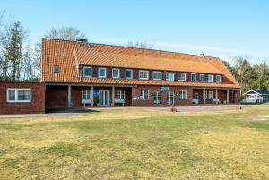 duży ceglany budynek z pomarańczowym dachem w obiekcie campushus w mieście Sankt Peter-Ording