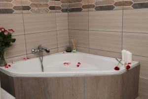 a bath tub in a bathroom with flowers on it at Rondy Bosch Lodge in Louis Trichardt