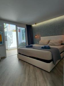 a bedroom with a large bed and a large window at Casa Maga in Maspalomas