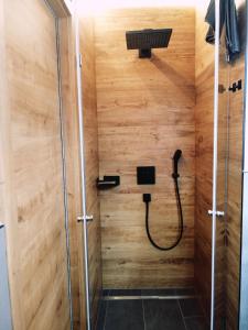 a shower with a hose in a wooden wall at Das Prinzenberg Appartement in Maria Alm am Steinernen Meer